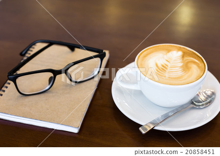 Coffee cup and notebook on table background. Coffee cup and notebook on table background. 20858451