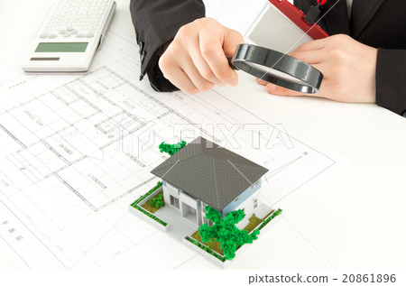 A woman looking through a residential model with a magnifying glass A woman looking through a residential model with a magnifying glass 20861896