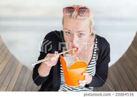 Woman eating Chinese take-away noodels. Woman eating Chinese take-away noodels. 20864516