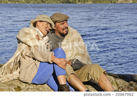 senior couple by lake blanket around shoulders 20867002