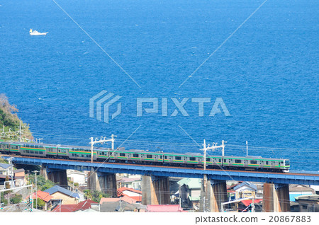 A regular train on the Tokaido line going through a railway bridge overlooking Sagami Bay A regular train on the Tokaido line going through a railway bridge overlooking Sagami Bay 20867883