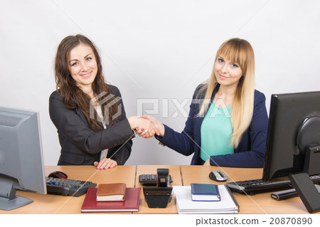 Two young girls acquainted shake hands and looked into the frame 20870890