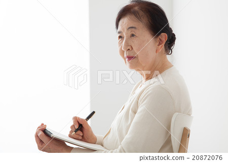 坐椅子和寫筆記的資深婦女個人歷史 坐椅子和寫筆記的資深婦女個人歷史 20872076