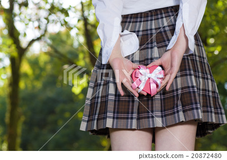 Female girls high school student with cute gift behind the back with green back No face 20872480