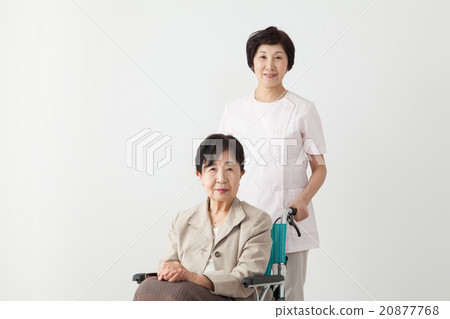 坐在輪椅和照料者的婦女的老年人 20877768