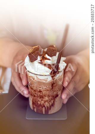 Hands holding banoffee on table. 20883717