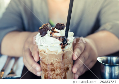 Hands holding banoffee on table. 20883721