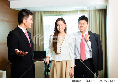 Asian Chinese hotel manager presenting suite 20890488