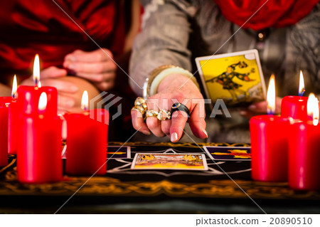Fortuneteller laying Tarot cards with client 20890510