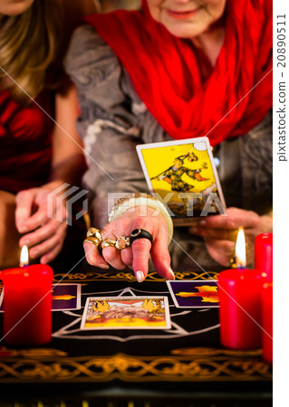 Fortuneteller laying Tarot cards with client Fortuneteller laying Tarot cards with client 20890511
