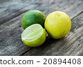 Two limes and sliced one on wooden table 20894408