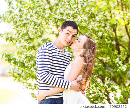 Loving couple under blossoming branches spring day Loving couple under blossoming branches spring day 20902232