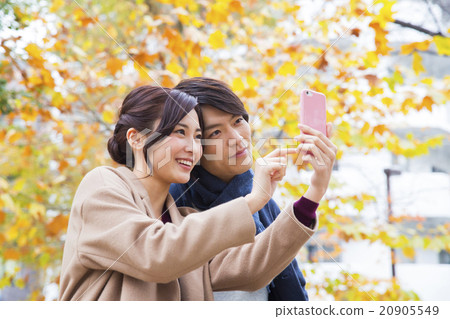 Portrait A couple manipulating smartphones outdoors Portrait A couple manipulating smartphones outdoors 20905549