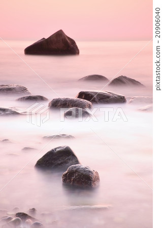 Romantic sea. Boulder sticking out from smooth sea 20906040