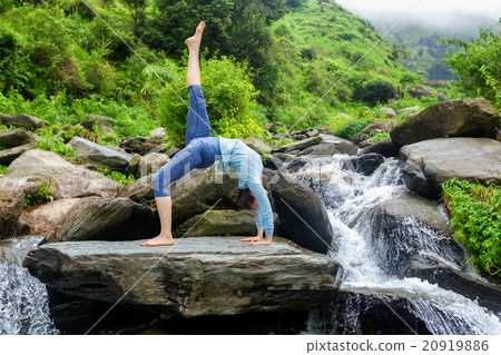 Woman doing yoga asana at waterfall 20919886