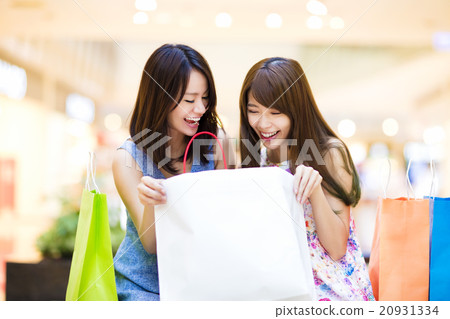 Happy woman looking at shopping bag at   mall 20931334