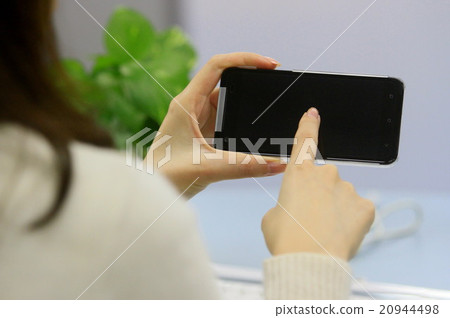 Woman holding a smartphone Woman holding a smartphone 20944498