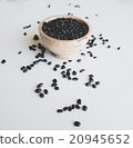 Black beans in a wooden bowl, scattering near 20945652