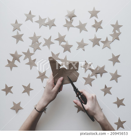 Woman's hands cut stars of craft paper 20945653