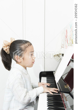 Girl playing the piano Piano Girl elementary school hobby Lesson Practice lesson Girl playing the piano Piano Girl elementary school hobby Lesson Practice lesson 20954382