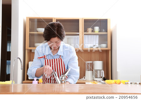 一個60多歲的女人站在廚房裡 一個60多歲的女人站在廚房裡 20954656