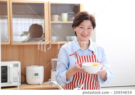 一個60多歲的女人站在廚房裡 一個60多歲的女人站在廚房裡 20954659