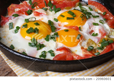 Fried eggs with tomatoes, green onions in a pan Fried eggs with tomatoes, green onions in a pan 20960601
