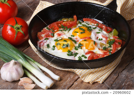 Fried eggs with vegetables on a frying pan Fried eggs with vegetables on a frying pan 20960602