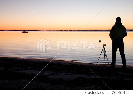 Silhouette of nature photographer at tripod at sea Silhouette of nature photographer at tripod at sea 20961404