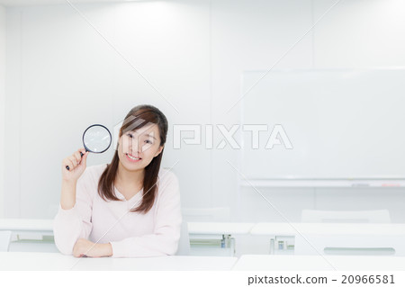 Woman holding a magnifying glass Looking at the camera 20966581