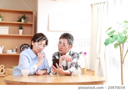 一對50歲的夫婦正在看智能手機 20970039