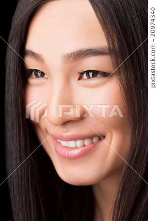 Close-up of smiling Asian woman in studio 20974340