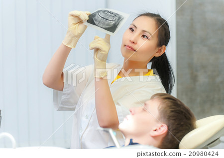 Dentist showing x-ray to a patient 20980424