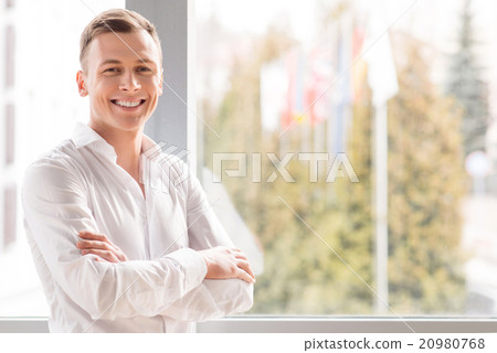 Positive man standing near window Positive man standing near window 20980768