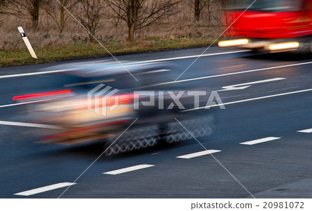 Speeding cars at a crossroad Speeding cars at a crossroad 20981072