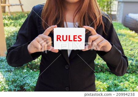 Businesswoman showing white sign with Rules word Businesswoman showing white sign with Rules word 20994238