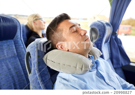 man sleeping in travel bus with cervical pillow 20998827