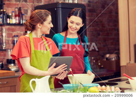 happy women with tablet pc cooking in kitchen happy women with tablet pc cooking in kitchen 20999006