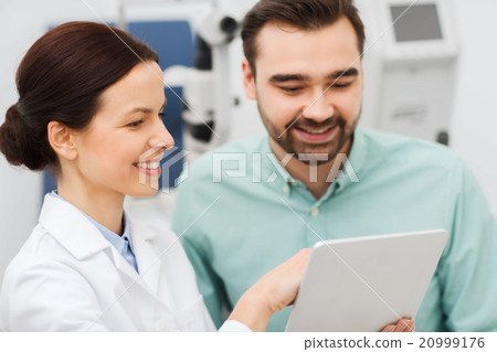 optician with tablet pc and patient at eye clinic 20999176