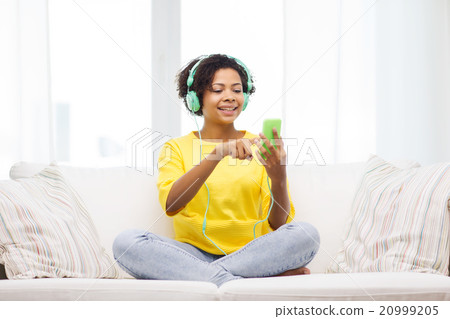 happy african woman with smartphone and headphones happy african woman with smartphone and headphones 20999205