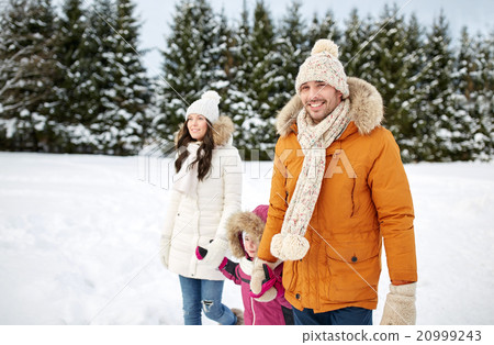 happy family in winter clothes walking outdoors 20999243