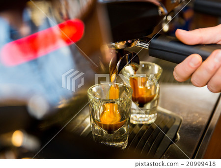 close up of woman doing espresso by coffee machine close up of woman doing espresso by coffee machine 20999418