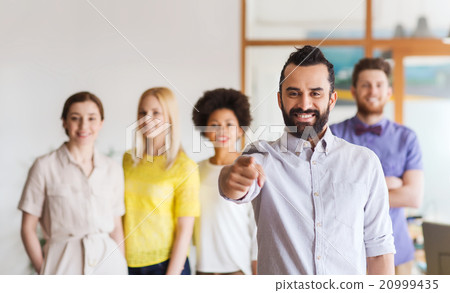 happy man pointing finger at you over office team 20999435
