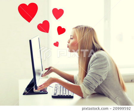 woman sending kisses with computer monitor woman sending kisses with computer monitor 20999592