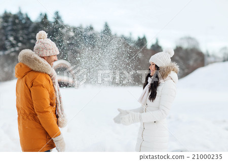 happy couple playing with snow in winter 21000235