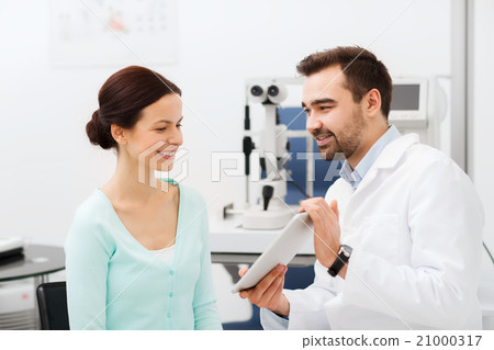 optician with tablet pc and patient at eye clinic 21000317