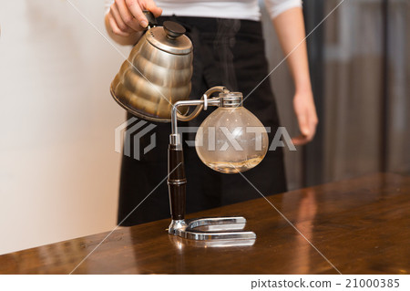 close up of woman with siphon coffee maker and pot 21000385