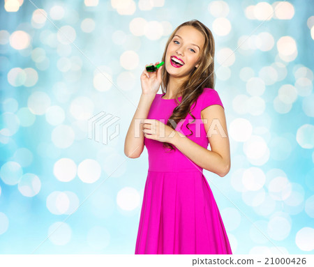 happy young woman or teen girl with party horn happy young woman or teen girl with party horn 21000426