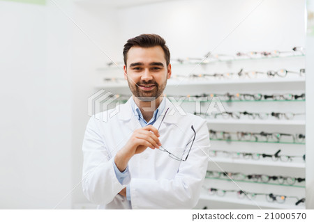 man optician with glasses in coat at optics store man optician with glasses in coat at optics store 21000570