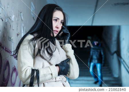 Young woman along at night at a danger 21002840